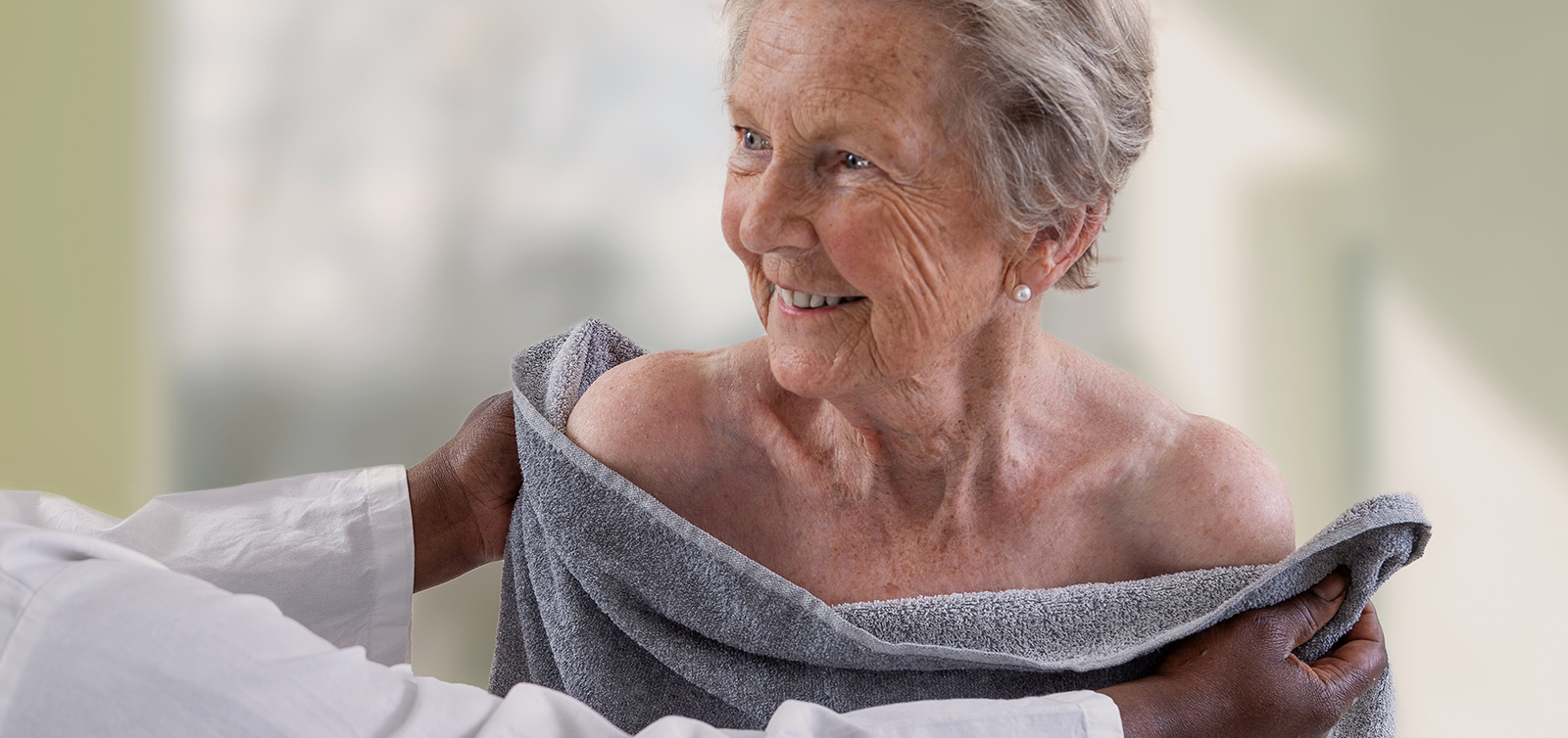 Caregiver che applica le cure igieniche sulla pelle di una persona anziana Caregiver che applica le cure igieniche sulla pelle di una persona anziana